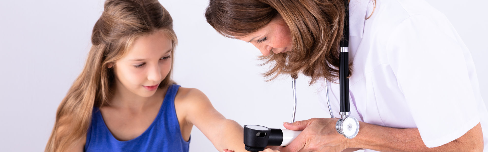 Doctor Examining Skin Of Girl